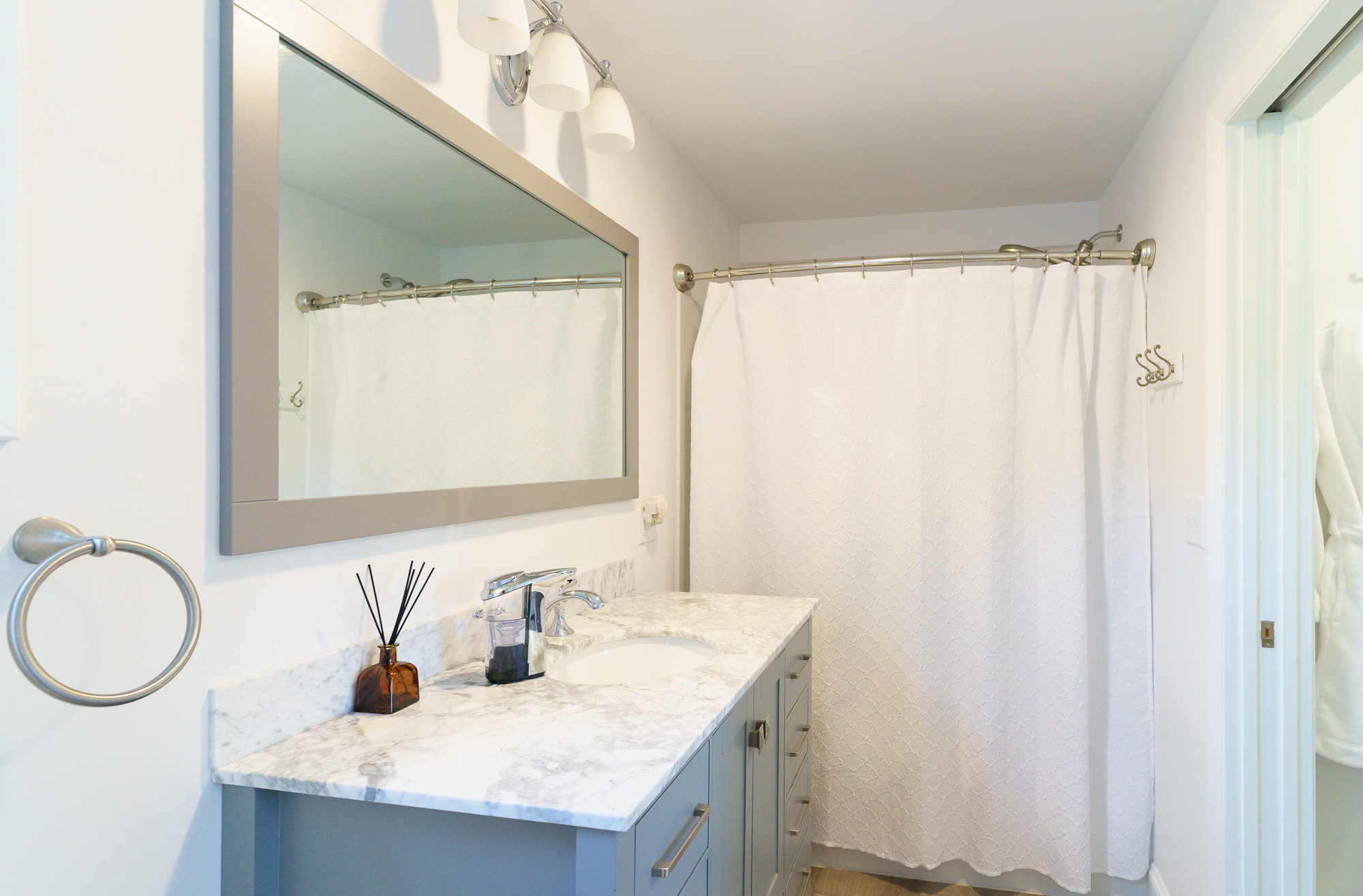 Bathroom vanity with shower curtain and mirror
