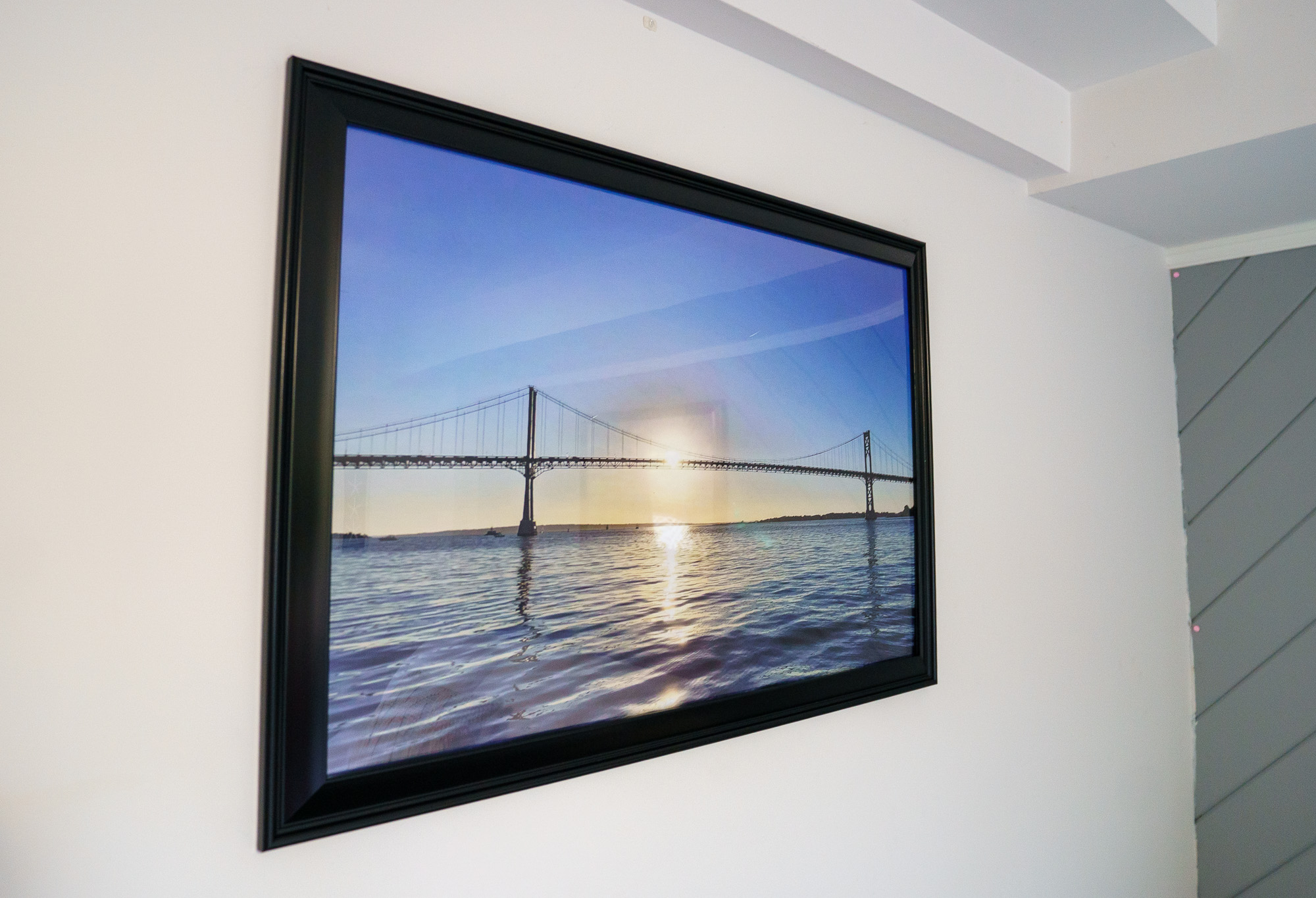 Framed sunset bridge photograph in the hallway